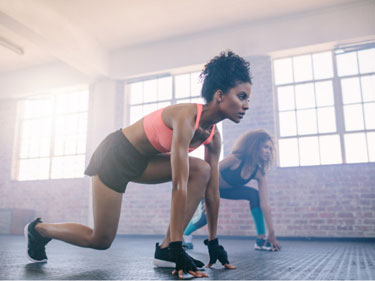 woman in workout clothes doing leg exercises on a workout mat