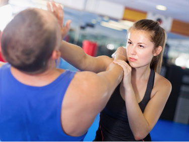 woman using self defense techniques to push back a man