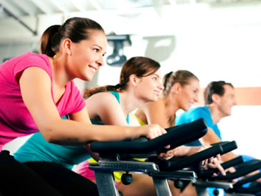 four people on bikes in a spin class