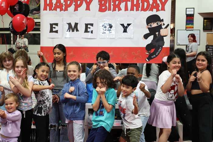 bday-700x466 group of kids in front of a sign saying happy birthday emory during a kids birthday party in Roseville at THE STUDIO Martial Arts, Ninja Gym and Fitness