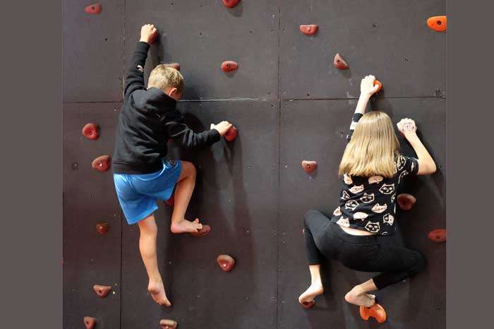 two kids on the climbing wall at the ninja gym at the studio in roseville